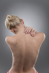 Woman massaging pain neck and back.