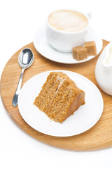 piece of honey cake, jug of cream and cup of cappuccino