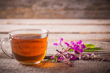 cup of tea with willow-herb on wooden background