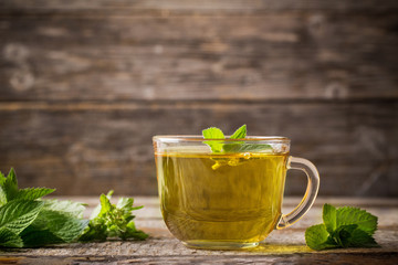 cups of tea with mint on wooden
