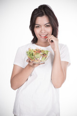 Pretty girl eating fresh vegetable salad