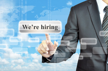 Businessman hand touching We're hiring  sign on virtual screen