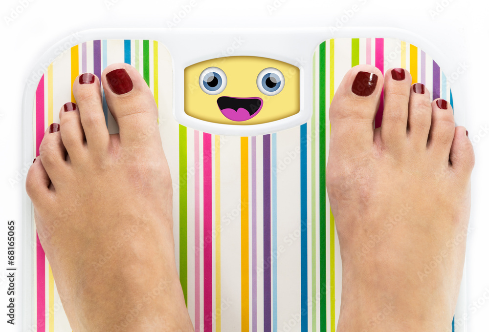 Wall mural Feet on bathroom scale with laughing cute face on dial