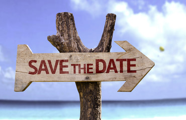 Save the Date wooden sign with a beach on background