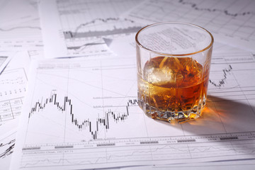 Glass of whiskey on charts