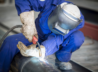 Worker with protective mask welding metal
