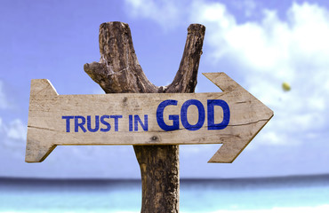 Trust in God wooden sign with a beach on background - obrazy, fototapety, plakaty