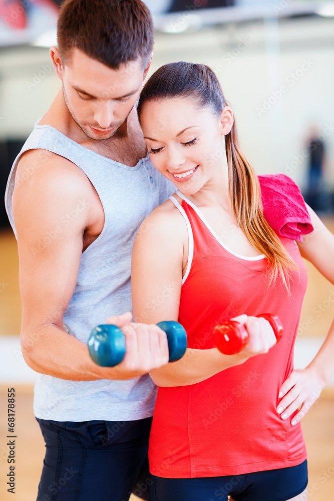 Wall mural two smiling people working out with dumbbells