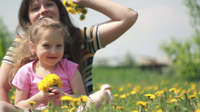 Mom and daughter throw their bouquet of dandelions