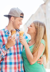 smiling couple with ice-cream in city
