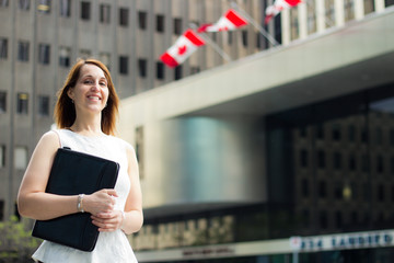 Cheerful business woman walking downtown in a Canadian city