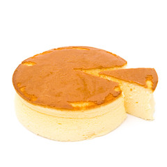 side view round cheese cake with one piece cut out on white