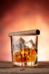 Faceted glass with whiskey and cigar