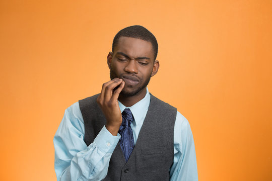 Man with tooth ache, pain, isolated on orange background 
