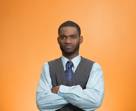 Grumpy, skeptical, displeased man on orange background 