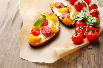 Tasty bruschetta with tomatoes, on old wooden table