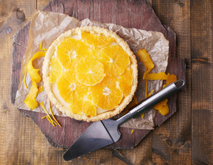 Homemade orange tart on wooden background