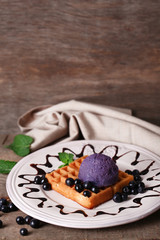 Tasty belgian waffles with ice cream on wooden table