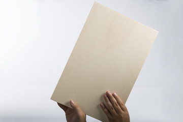 Plywood sign held up by young hands