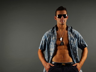 Obraz premium Young man in sunglasses poses with cigarette