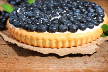 Tasty homemade pie with blueberries on wooden table