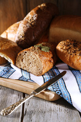 Composition of fresh baked bread, knife and kitchen towel,