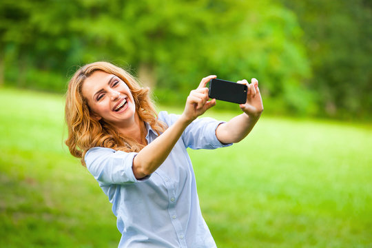 Nice woman taking pictures with smartphone
