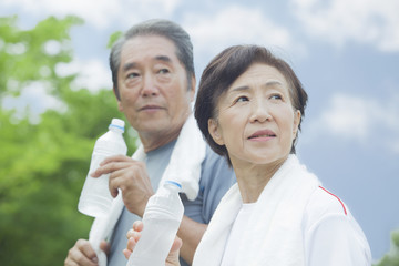 ペットボトルの水を飲むシニア