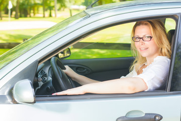 Fototapeta na wymiar Happy young woman driving a car