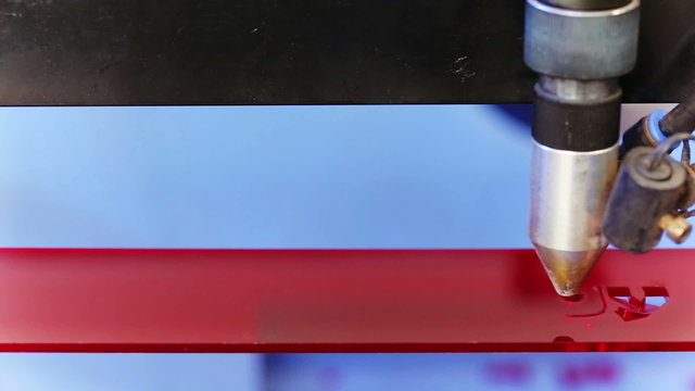 Laser cnc machine cutting technology word on red acryl plate