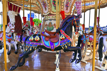 Obraz na płótnie Canvas Retro merry-go-round with brightly decorated ponies.
