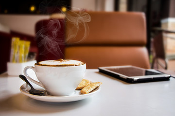 coffee and tablet on table in cafe