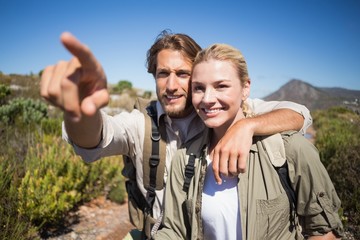 Happy hiking couple walking on mountain terrain