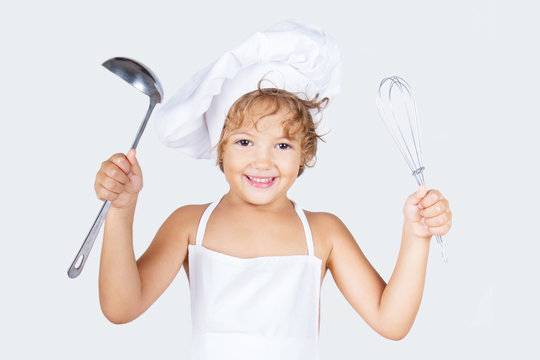 Bambina con utensili da cucina