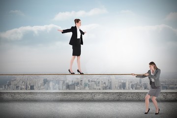 Young businesswoman pulling a tightrope for business woman