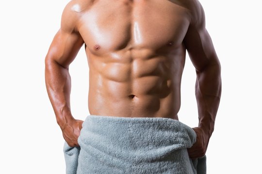 Mid section of a shirtless muscular man wrapped in towel