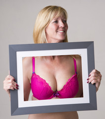 Woman holding picture frame Framing her bra