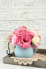 Bouquet of eustoma flowers in vase on wooden background