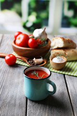 Homemade tomato juice in color mug, bread sticks, spices and