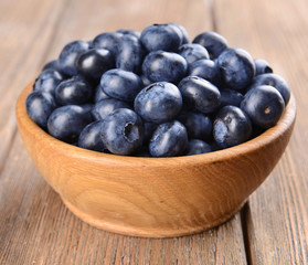 Delicious blueberries in bowl on table close-up