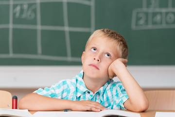 junge in der schule schaut traurig nach oben