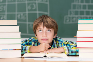 genervter schüler zwischen bücherstapeln