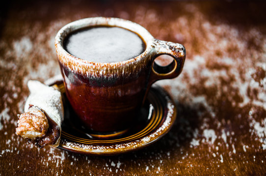 Rustic mug of coffee on wooden background