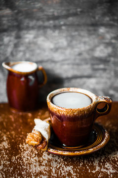 Rustic mug of coffee on wooden background