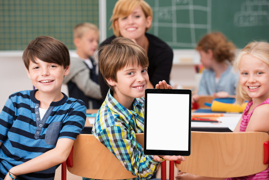 lachende kinder in der schule zeigen tablet