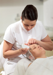 Obraz na płótnie Canvas Cosmetician providing ultrasonic facial cleaning