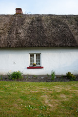 small window on traditional irish thatched cottage
