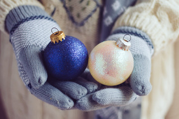 Woman wearing gloves and holding Christmas balls