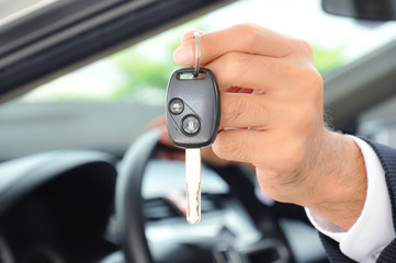 Hand holding a car key - car sale & rental business concept