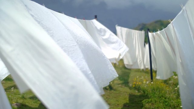 Washed white bed sheets  swaying gracefully in the wind